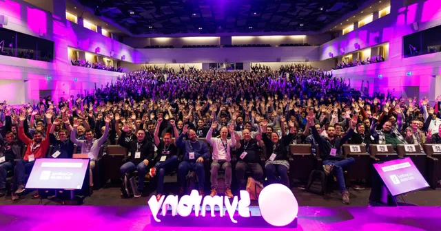 Crowd raising hands in the main auditorium at SymfonyCon Brussels 2023