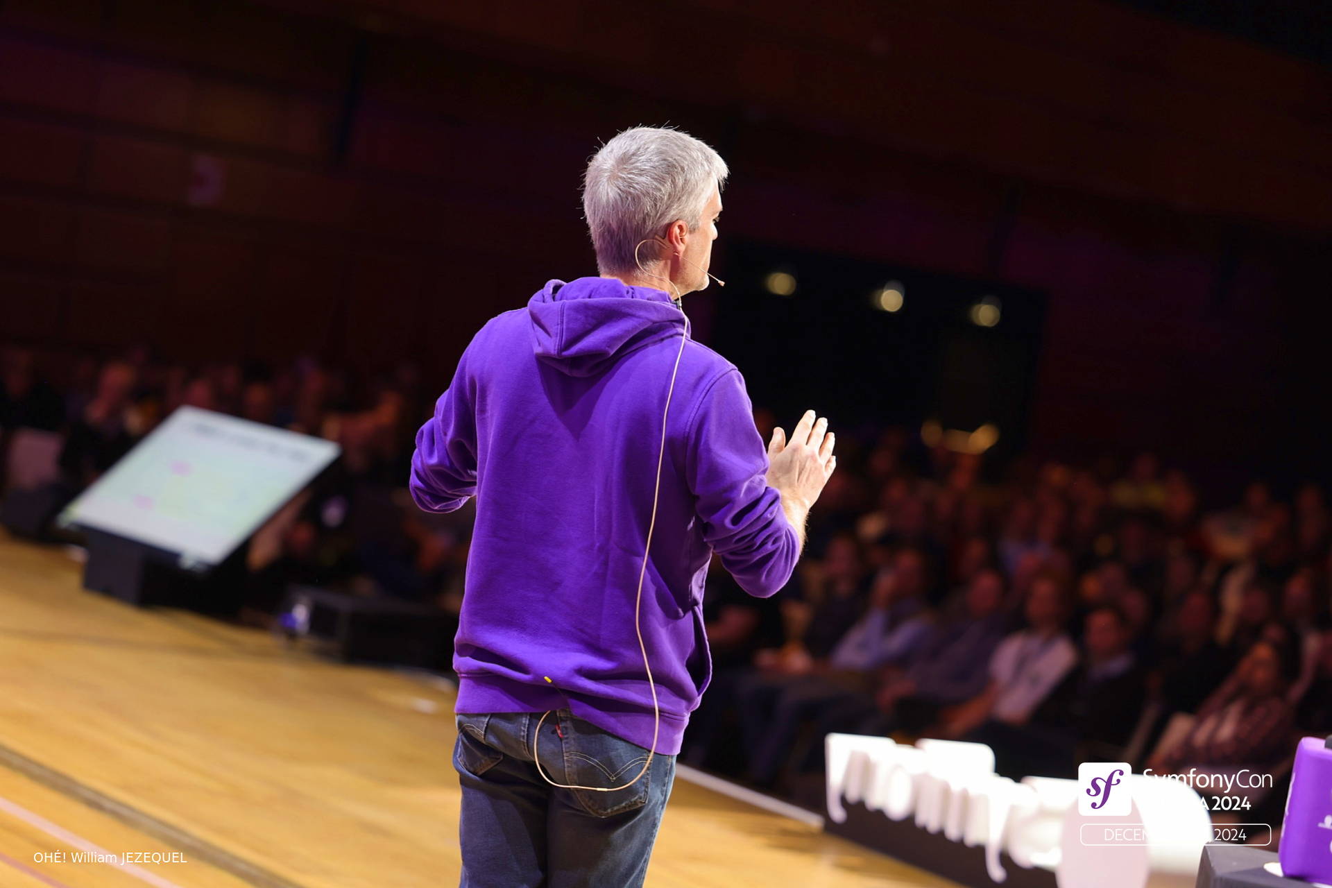 Fabien Potencier in a purple sweatshirt speaking in front of the audience at SymfonyCon Vienna 2024