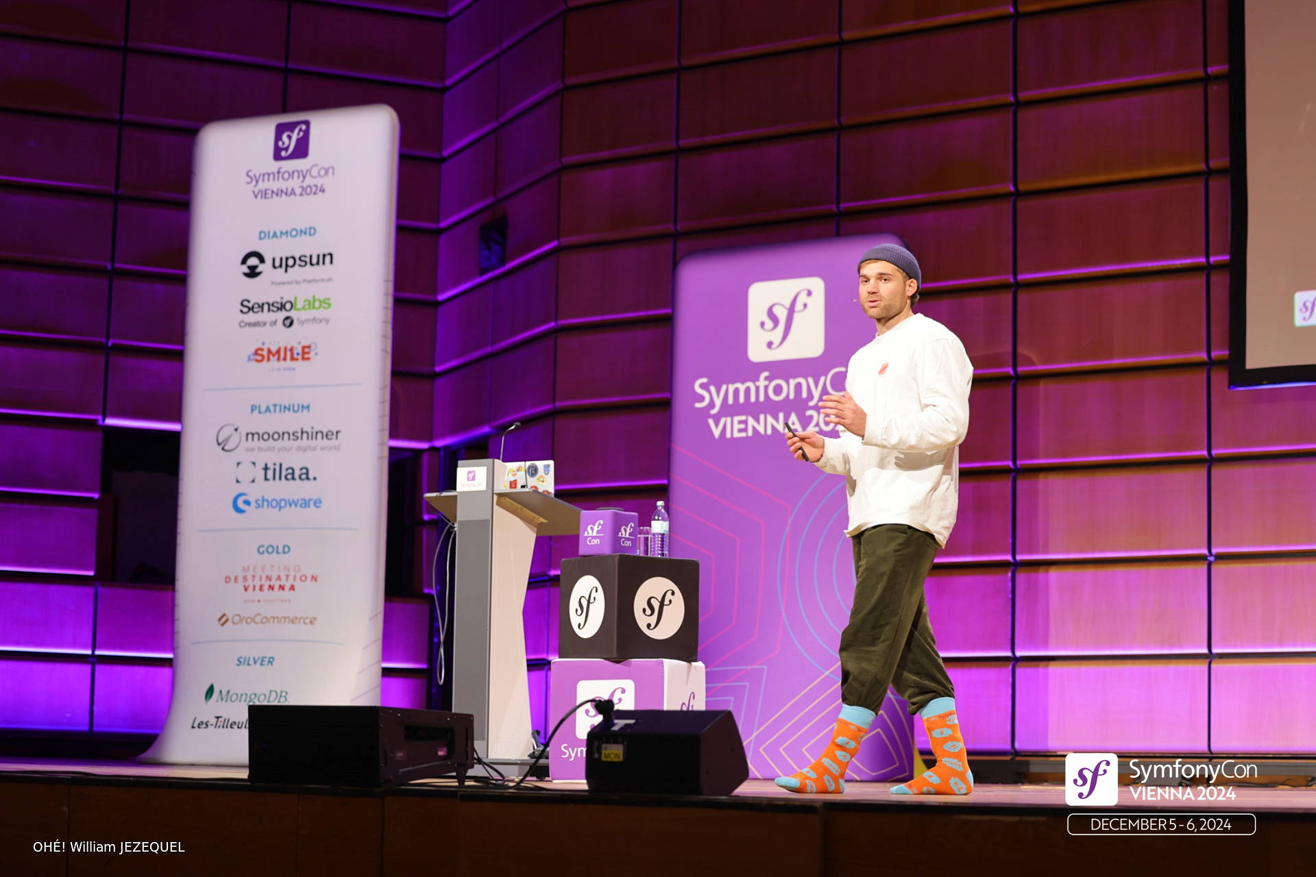 Matheo Daninos speaking on the main stage at SymfonyCon Vienna 2024 with SymfonyCasts socks