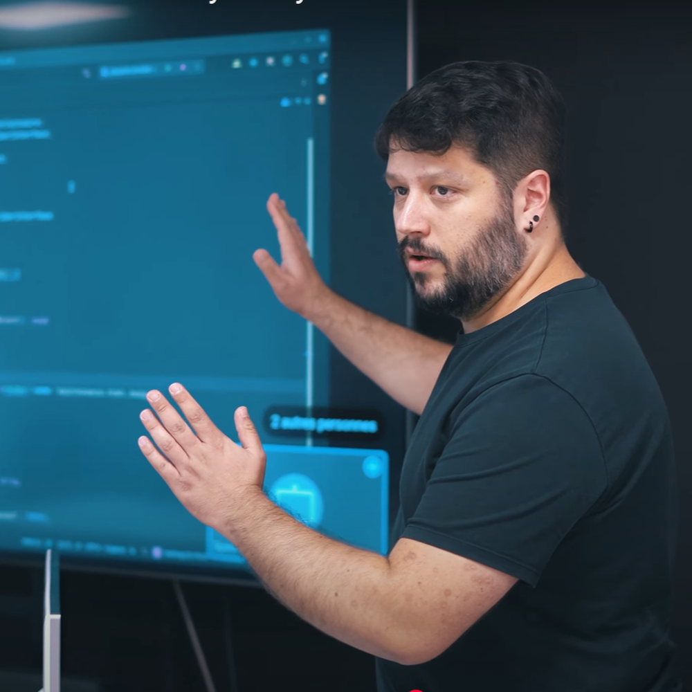 A bearded trainer explaining code displayed on a screen