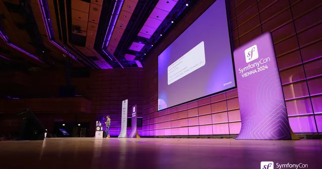 Main stage at SymfonyCon Vienna 2024 with a purple light and a large screen